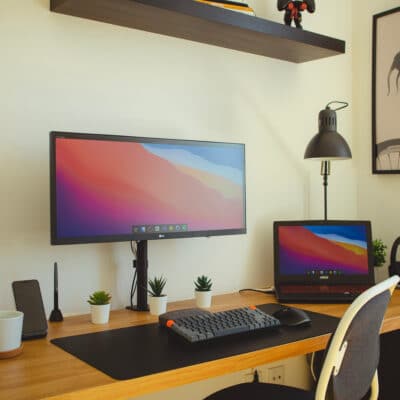 A desk with a computer and monitors in a home office - square