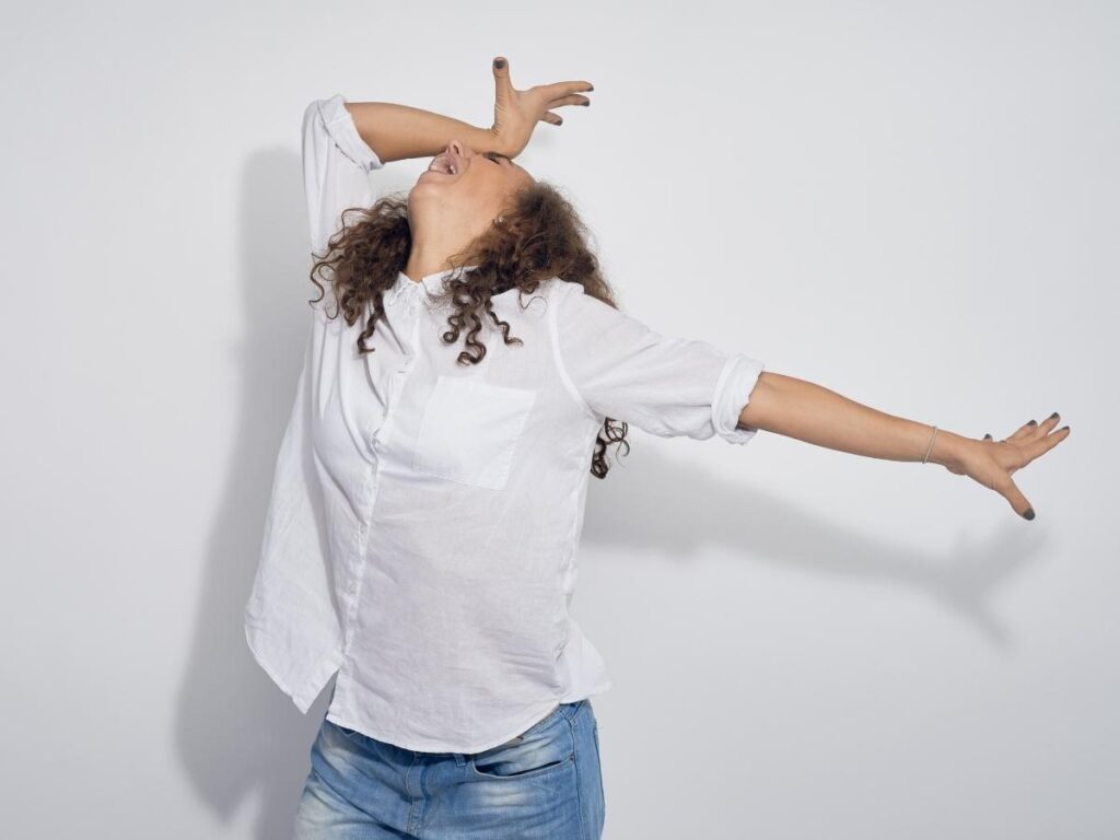 Woman with her head back one arm outstretched and the other on her forehead