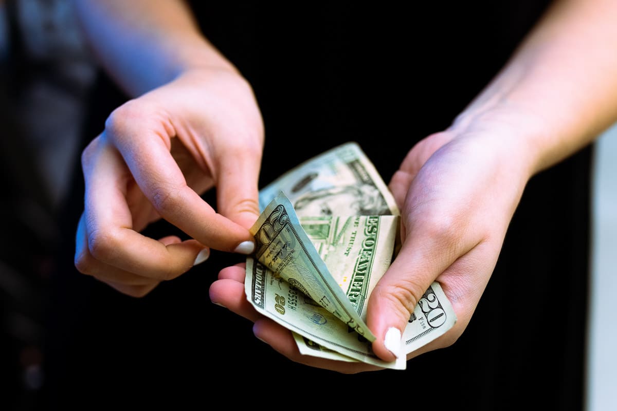 A woman's hand flipping through money