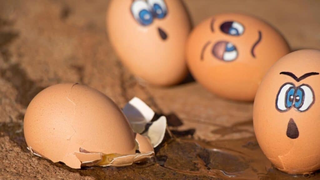 Broken egg surrounded by eggs with face painted on them